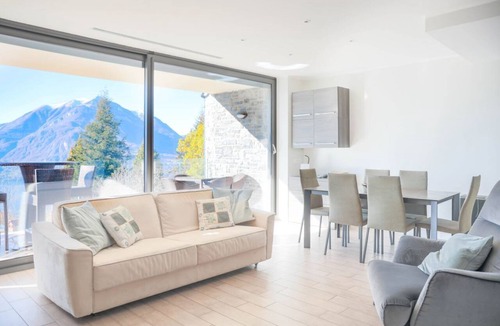 Perledo Apartment | In a panoramic position, modern apartment on the first floor of a new residence with SPA. Large windows frame the unique landscape of Lake COMO.This apartment has a beautiful terrace, with table and chairs and a sofa. The living room is a large open spac